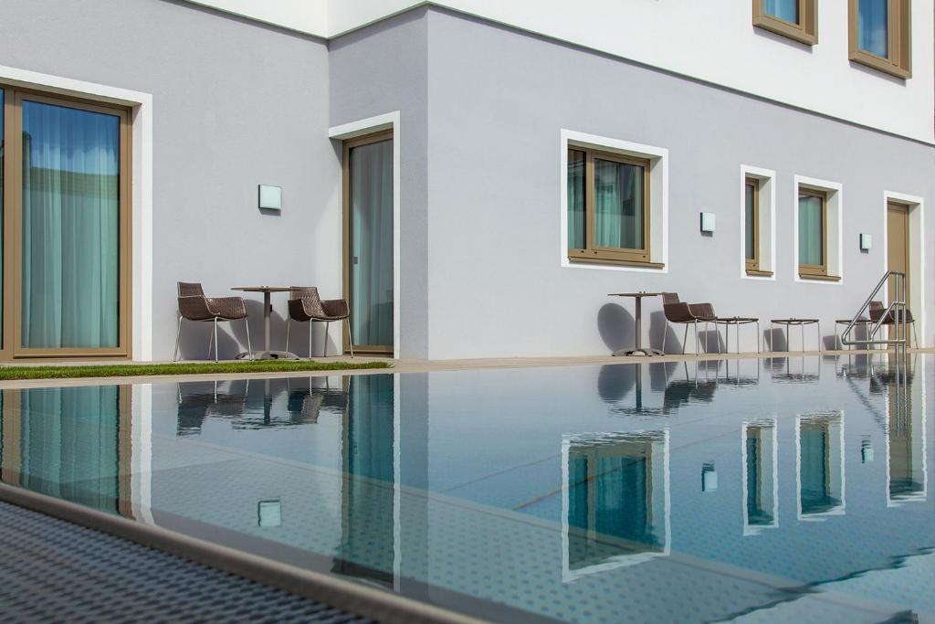 una piscina infinita con sillas y una mesa junto a un edificio en Gästehaus Klinglhuber, en Krems an der Donau