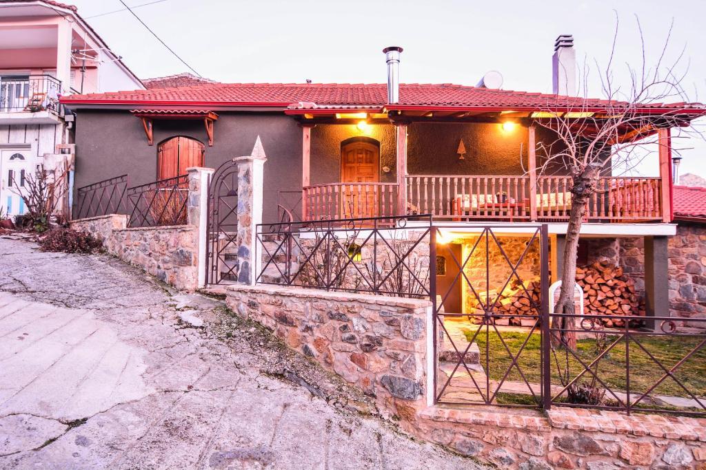a house with a balcony and a gate at Capris Rustic Ηouse with Mountain View in Archaia Feneos