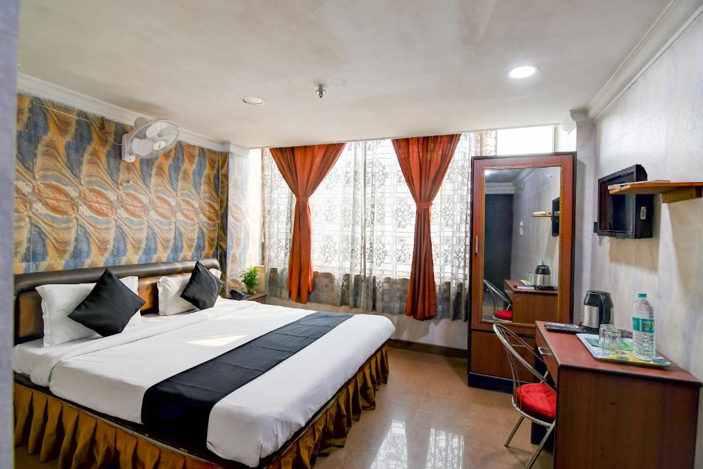a bedroom with a bed and a desk and a computer at Raj Palace Near City Centre 2 in kolkata