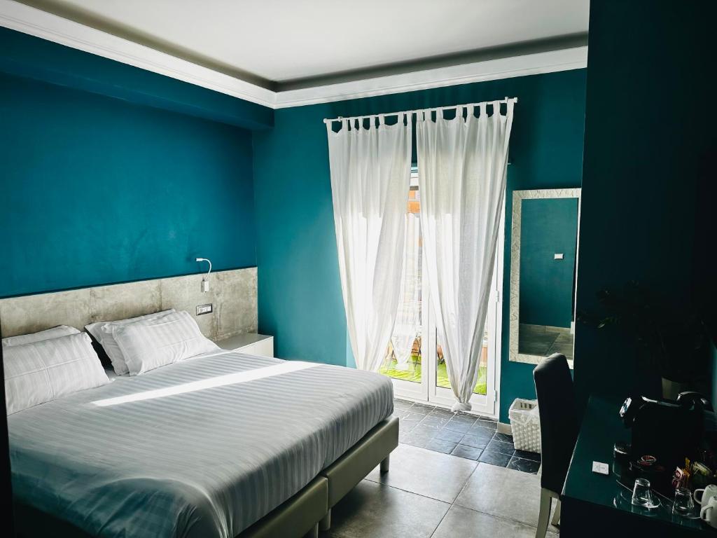 a blue bedroom with a bed and a window at Trastevere House in Rome