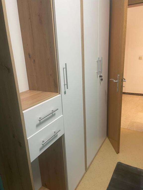 ein Schrank mit zwei weißen Schubladen und einer Tür in der Unterkunft Chambre Dresden in Trier