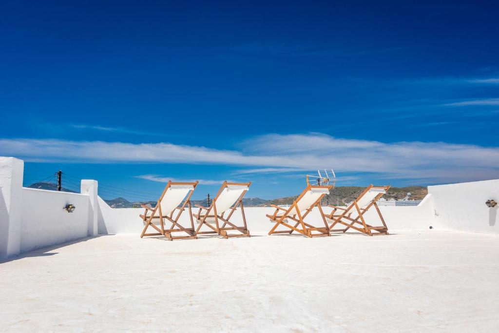 a group of chairs sitting on the beach at Olive In Blue in Adamas