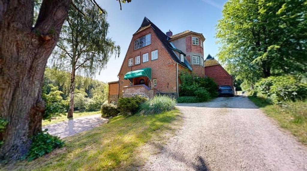 a large red brick house with a driveway at Reiterpension Marlie in Scharbeutz