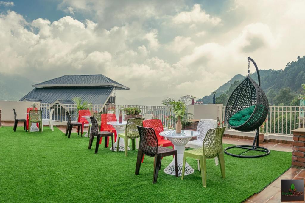 a group of chairs and tables on a lawn at The Countryside Retreat Kufri I Open Air Terrace I Bonfire I by Exotic Stays in Kūfrī