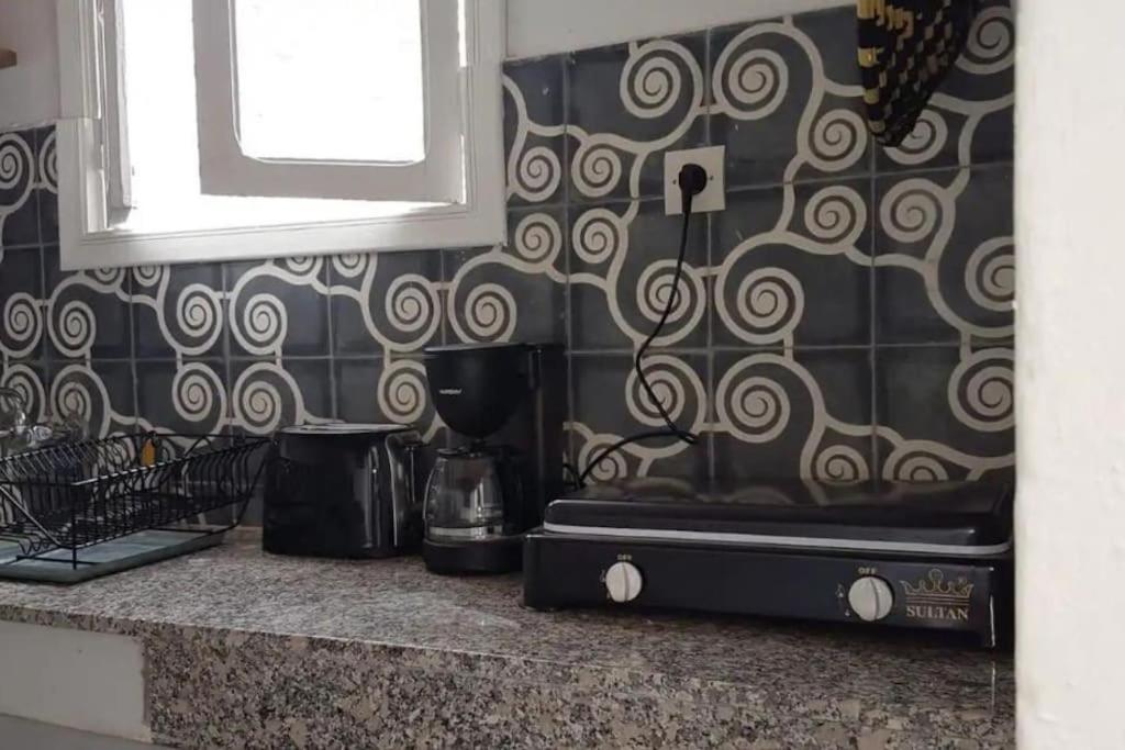 una cucina con bancone, macchinetta del caffè e finestra di Douiria le pélican a Marrakech