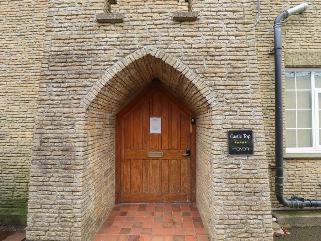 a brick building with a wooden door in it at Castle Top Haven in Market Rasen
