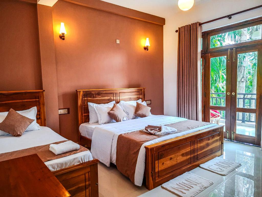 a bedroom with two beds and a window at Ella, Nine Glow Resort in Ella