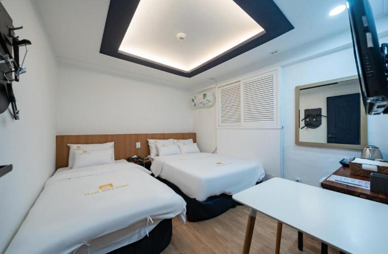 ein Krankenhauszimmer mit 2 Betten und einem Tisch in der Unterkunft Must Stay Mokdong in Seoul