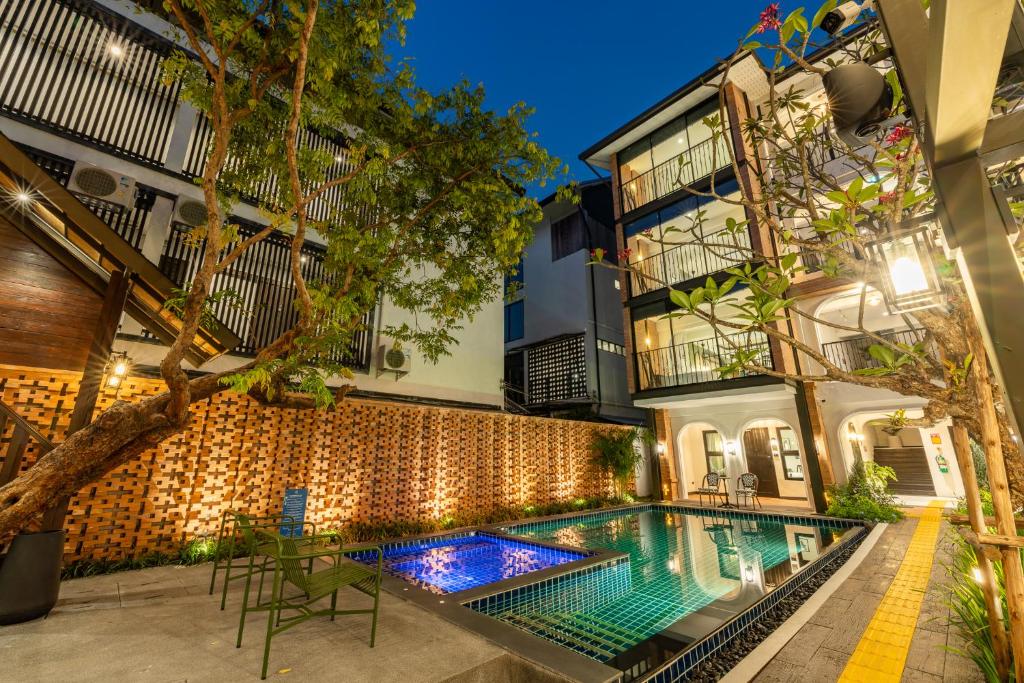 an exterior view of a house with a swimming pool at Shamrock Chiangmai Hotel in Chiang Mai