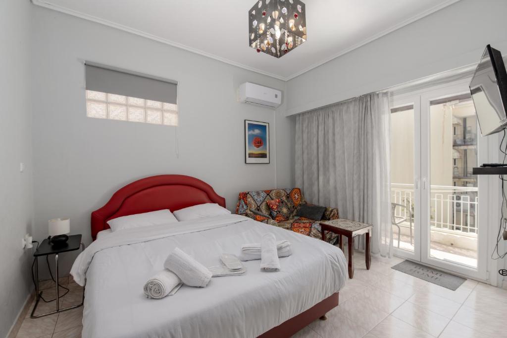 een slaapkamer met een groot wit bed en een stoel bij Alimos Marina Cozybase in Athene