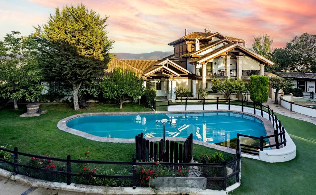 ein Haus mit einem Pool vor einem Haus in der Unterkunft CORTIJO LANDETE in Granada