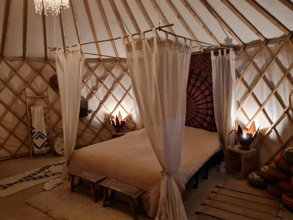 a bedroom with a bed in a yurt at Vakantiewoning in monumentale boerderij met yurt in Eckelrade