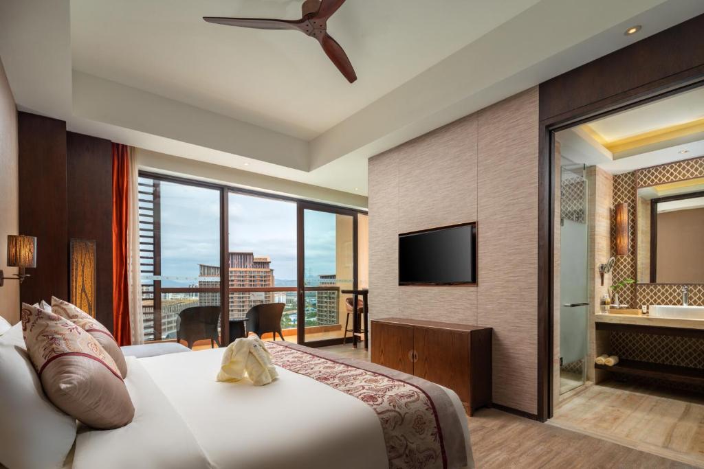 um quarto de hotel com uma cama e uma televisão em Mangrove Tree Resort World Sanya Bay- Queen Palm Towers em Sanya
