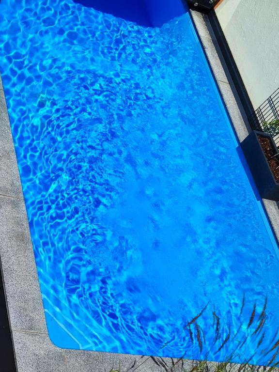 a swimming pool with blue water in it at LUXUS sApartments in der Kunstvilla &amp; kostenloses parken in Premstätten