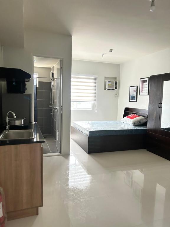a kitchen with a bed and a sink in a room at BRIA FLATS LAS PINAS in Manila