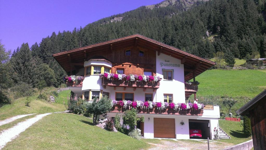 ein Haus mit Blumen an der Seite eines Hügels in der Unterkunft Haus Panorama in Sankt Leonhard im Pitztal