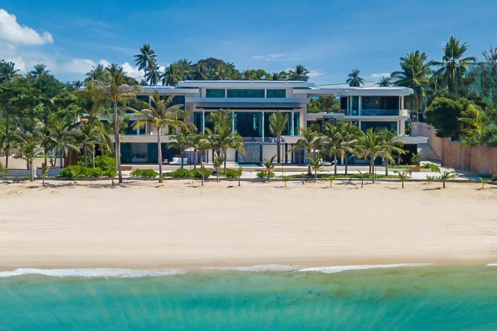a large house on the beach with the ocean at Villa Boonta in Phuket Town