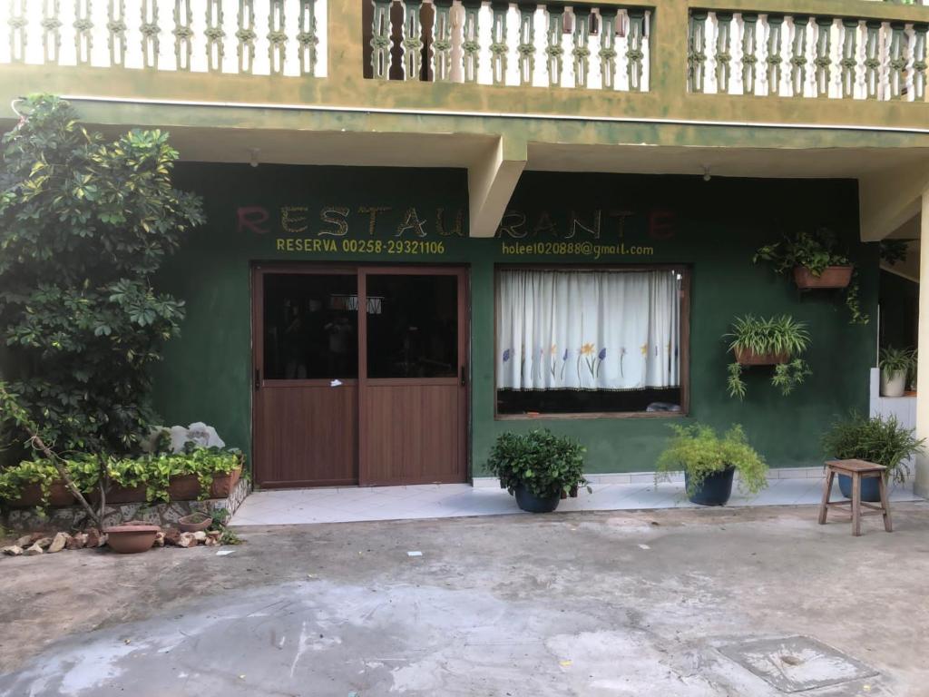 a restaurant with a green building with a door at Hotel Bom Amigo in Inhambane