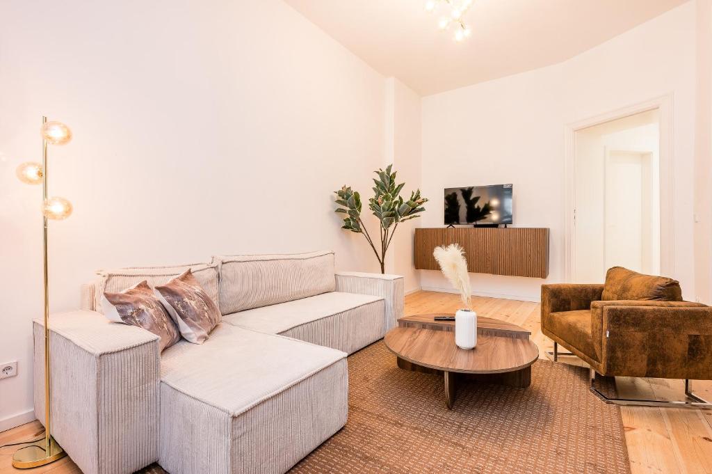 a living room with a couch and a table at Schiller Apartment Neukölln in Berlin