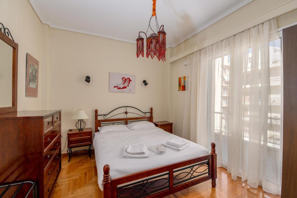 a bedroom with a bed and a large window at Alimos Marina Sunnyhub in Athens