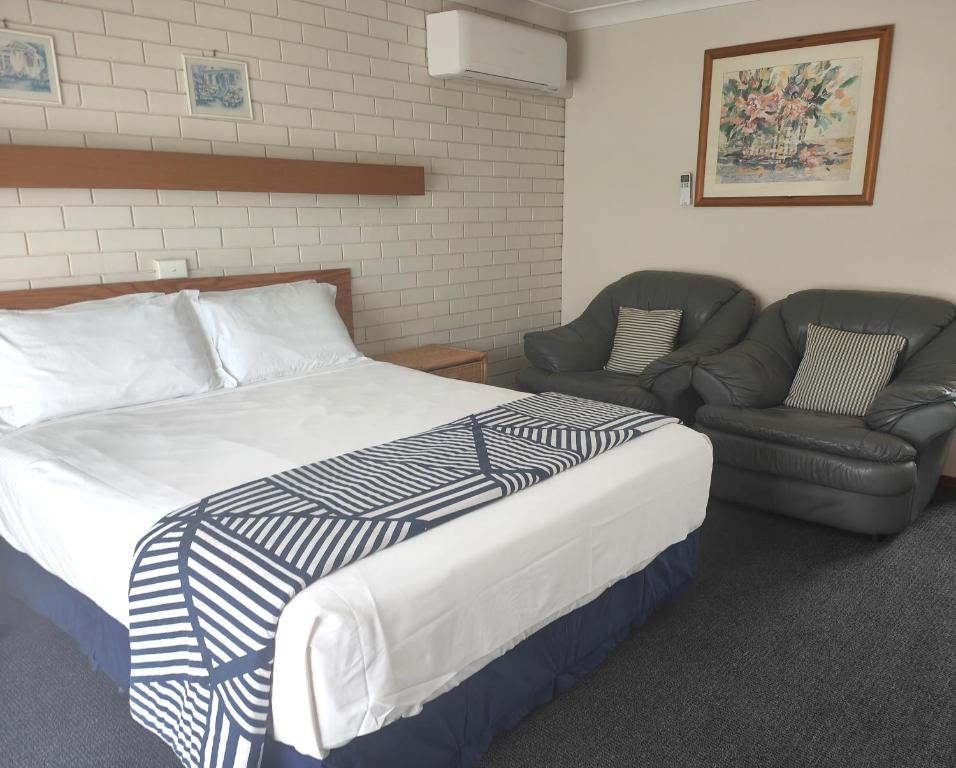 1 dormitorio con 1 cama y 2 sillas en Alfred Motor Inn, en Ballarat