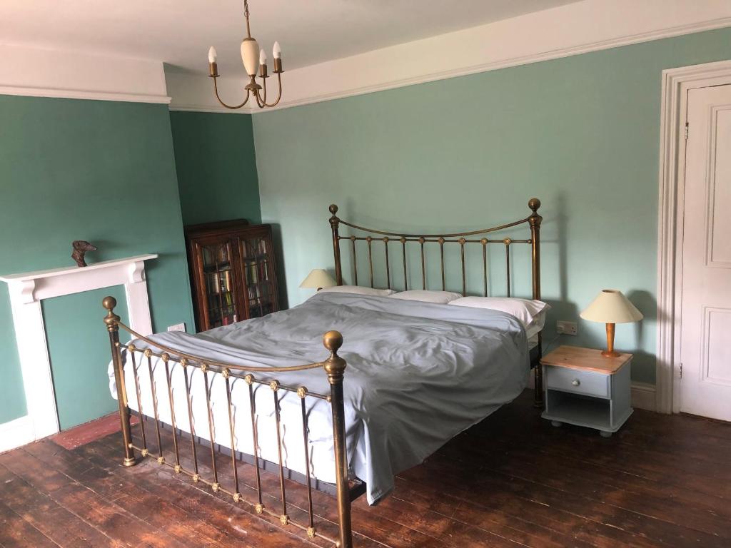 a bed in a bedroom with green walls at No 37 in Bridport