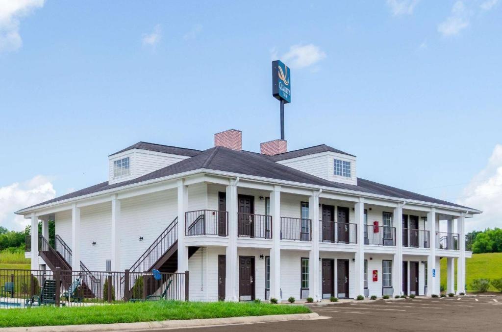 ein weißes Gebäude mit einer Flagge darüber in der Unterkunft Quality Inn in Vicksburg