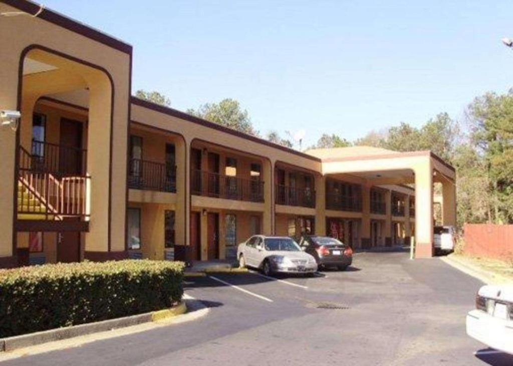 a building with two cars parked in a parking lot at Econo Lodge in Decatur