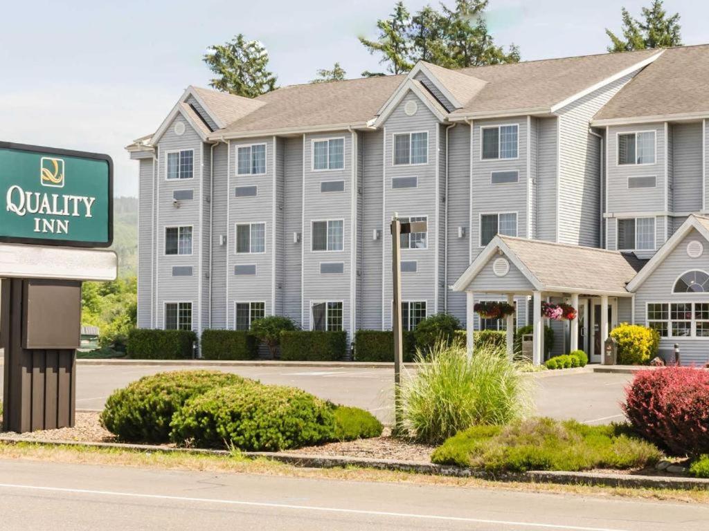 a large apartment building with a sign in front of it at Quality Inn in Seaside