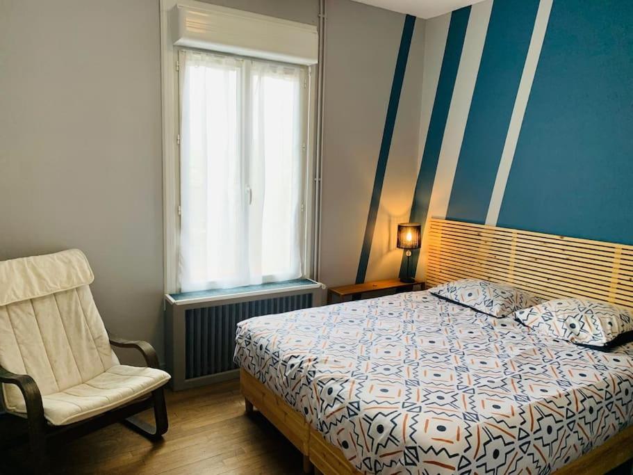 une chambre avec un lit, une chaise et une fenêtre dans l'établissement La maison de Charlotte, à Vierzon