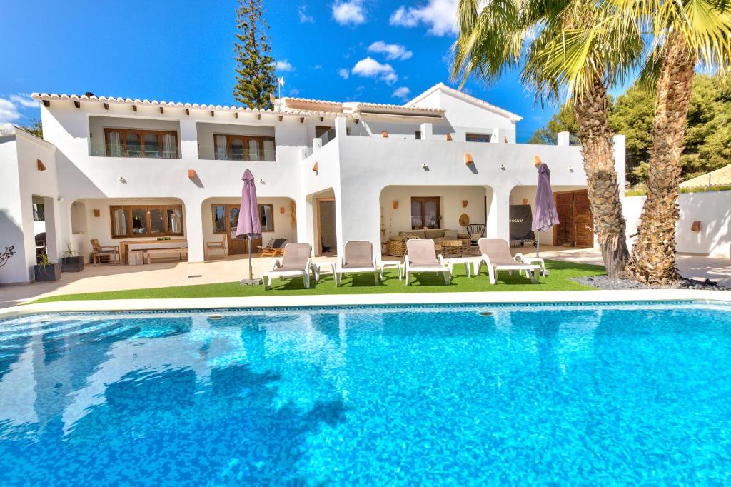 Villa con piscina frente a una casa en Heavenly, Luxury Villa, Moraira, en Teulada