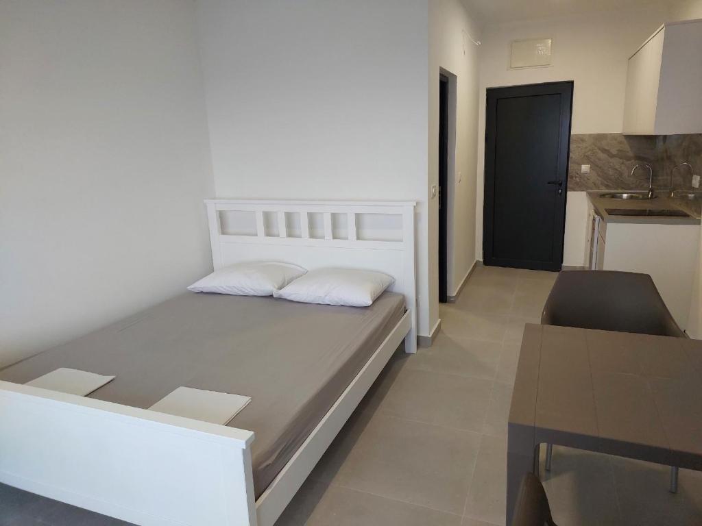 1 dormitorio con cama, mesa y cocina en Top Apartments, en Dobra Voda