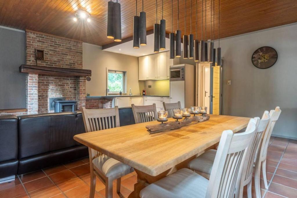 een keuken en eetkamer met een houten tafel en stoelen bij 2 bedrooms chalet with enclosed garden and wifi at Merksplas Merksplas 