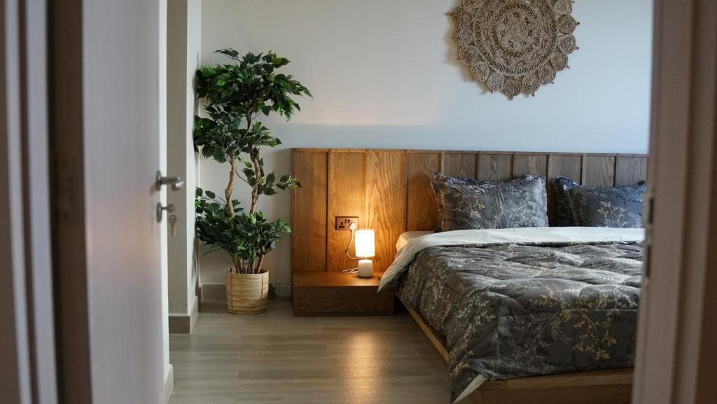 a bedroom with a bed and a plant and a lamp at 2 bedroom apartment Wabi Sabi in Yas in Abu Dhabi