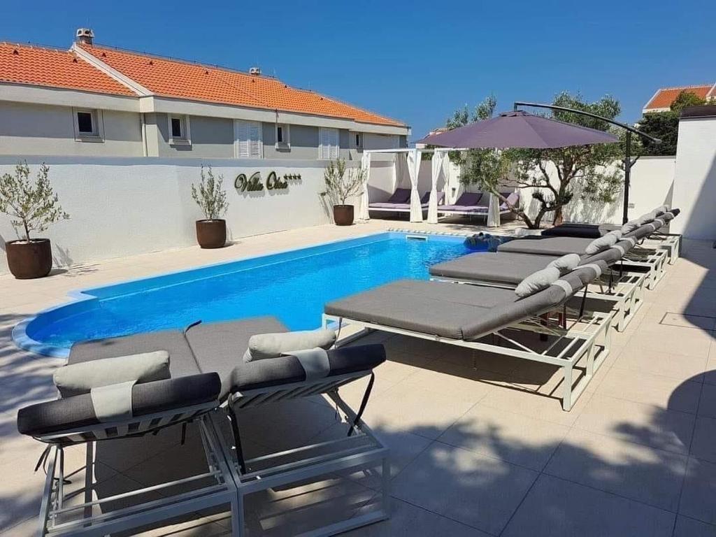 a group of lounge chairs and a swimming pool at Villa Olea in Šimuni