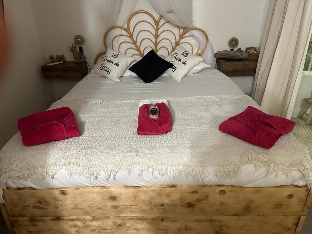 een slaapkamer met een bed met rode badjassen bij Le cocon de sissy in Saintes-Maries-de-la-Mer