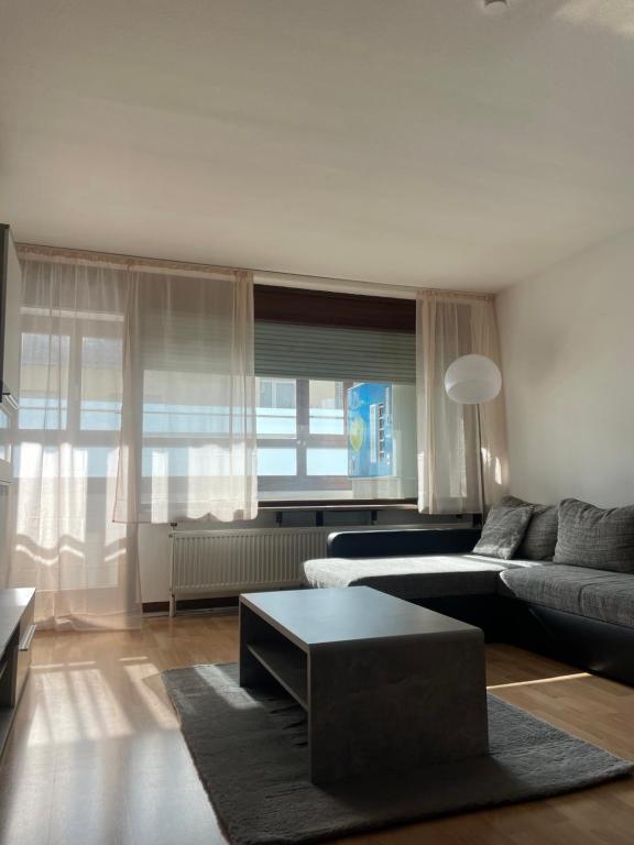 ein Wohnzimmer mit einem Sofa und einem Tisch in der Unterkunft Ruhige 2-Zimmer-Wohnung für 1 - 4 Personen nahe Würzburg von privat in Gerbrunn