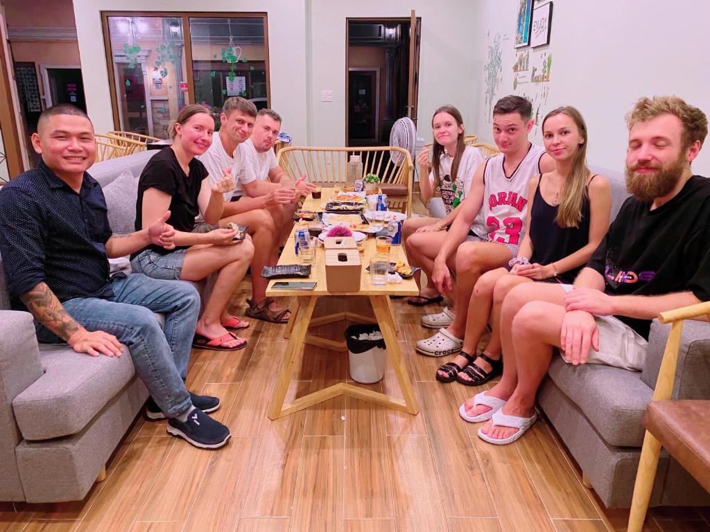 un grupo de personas sentadas en sofás en una sala de estar en Sunset Hotel Phu Quoc - welcome to a mixing world of friends en Phu Quoc
