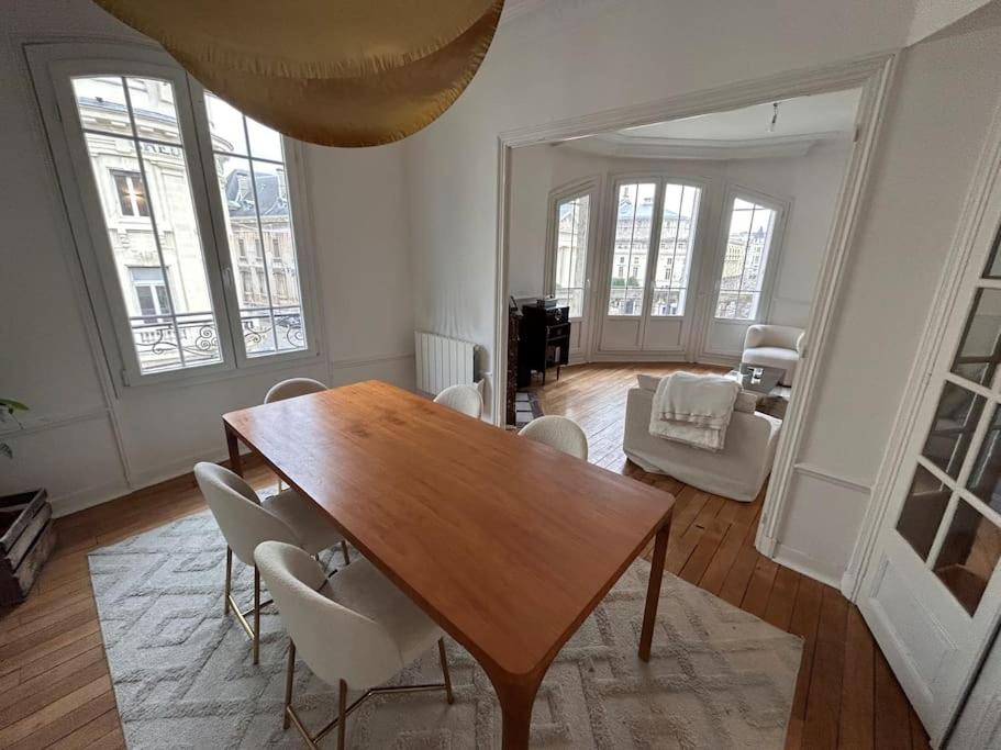 ein Wohnzimmer mit einem Holztisch und Stühlen in der Unterkunft * Le Cathédrale * in Reims