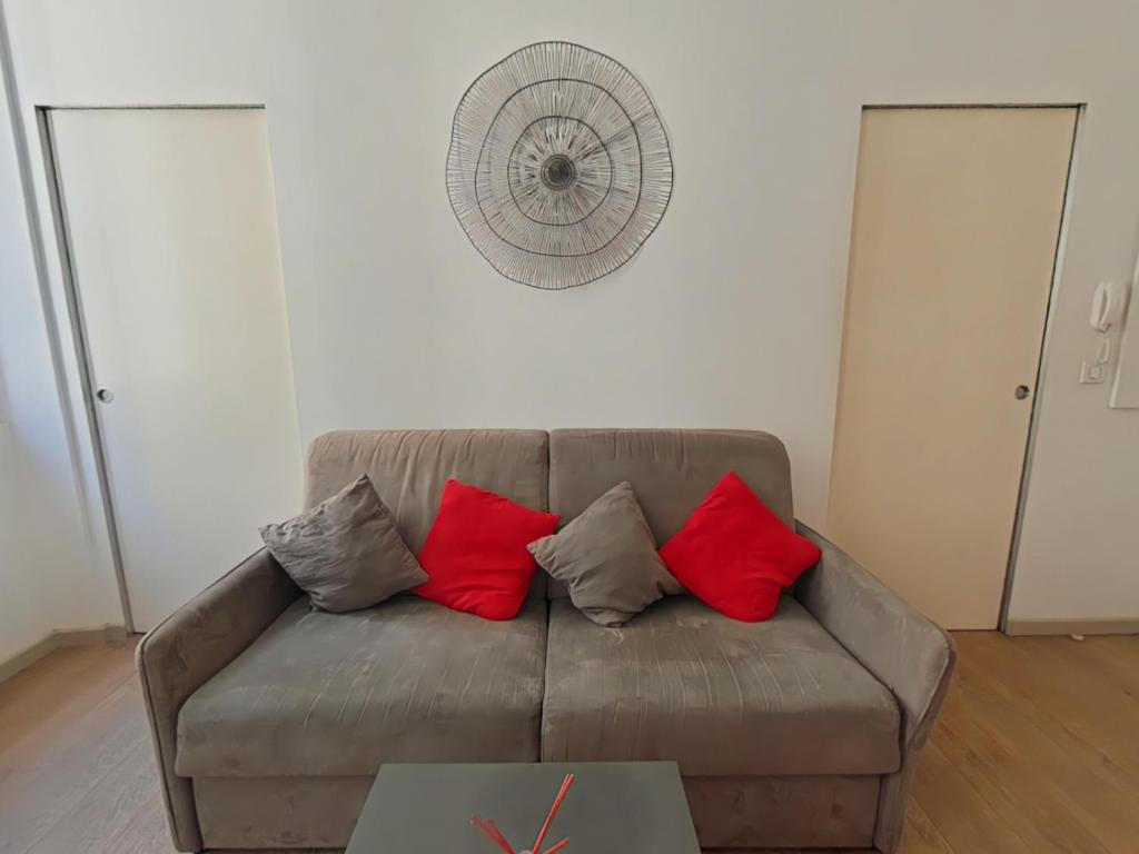 - un salon avec un canapé marron et des oreillers rouges dans l'établissement Molière Marseille, à Marseille