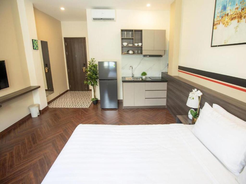 een grote kamer met een bed en een keuken bij CENTRAL BOUTIQUE HOTEL in Da Nang