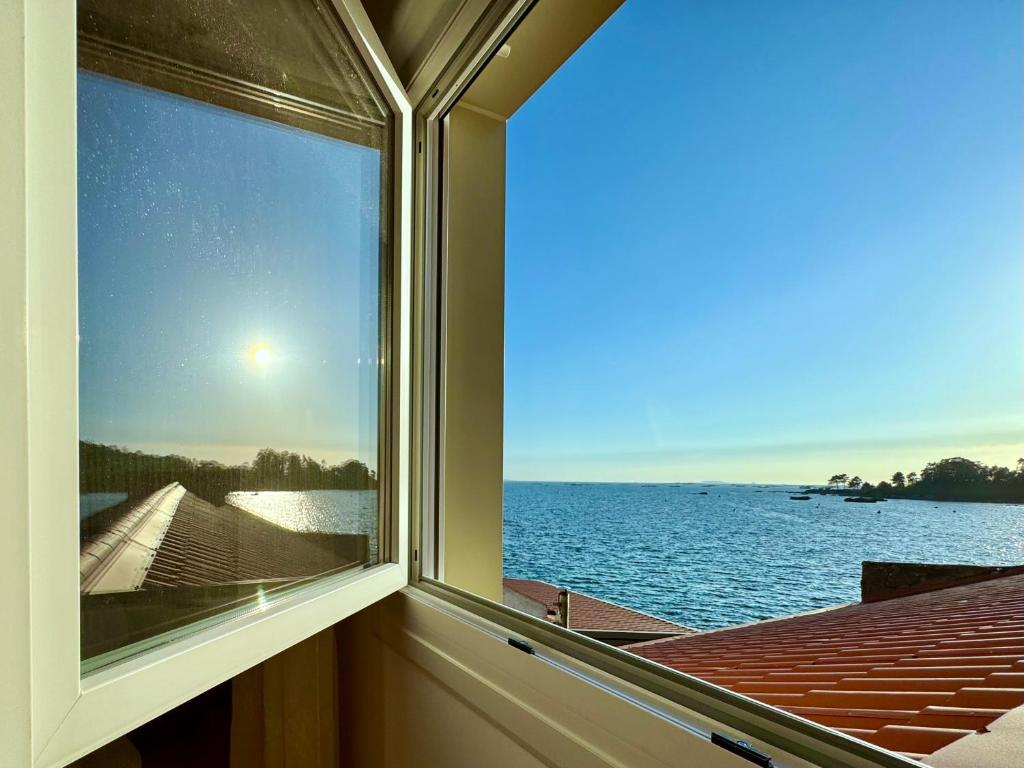 una ventana con vistas al agua en Apartamento Paseo Marítimo-A Illa de Arousa, en A Illa de Arousa