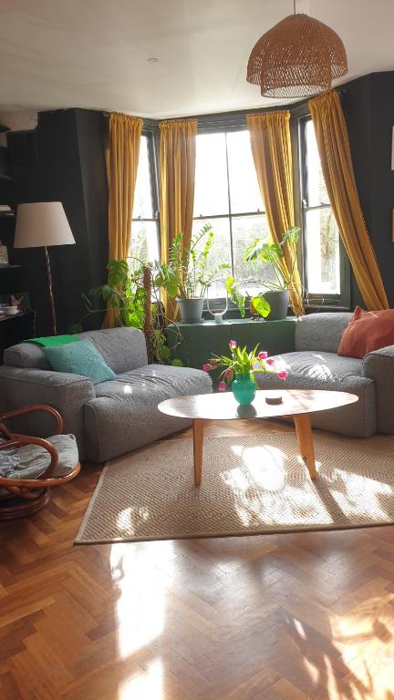 a living room with a couch and a coffee table at Charming bedroom in artist studio in London
