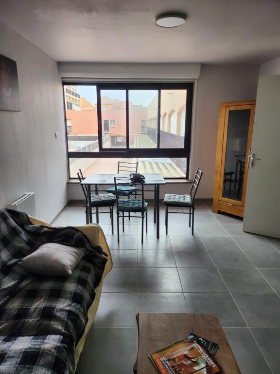 un salon avec une table, des chaises et un canapé dans l'établissement Le cap d'agde, au Cap d'Agde