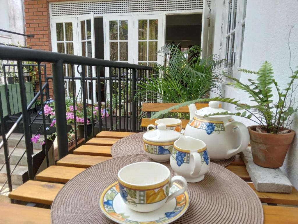 una mesa con tazas y platillos en el balcón en The Grove en Maharagama