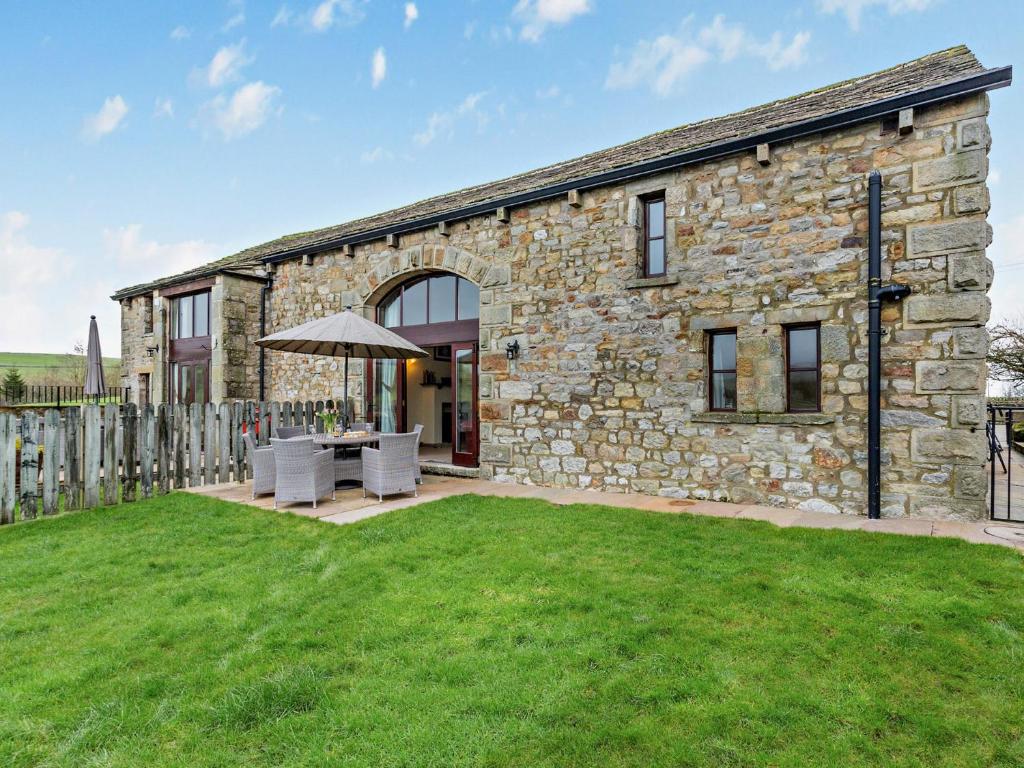 a stone building with a table and an umbrella at 3 Bed in Malham 94259 in Airton