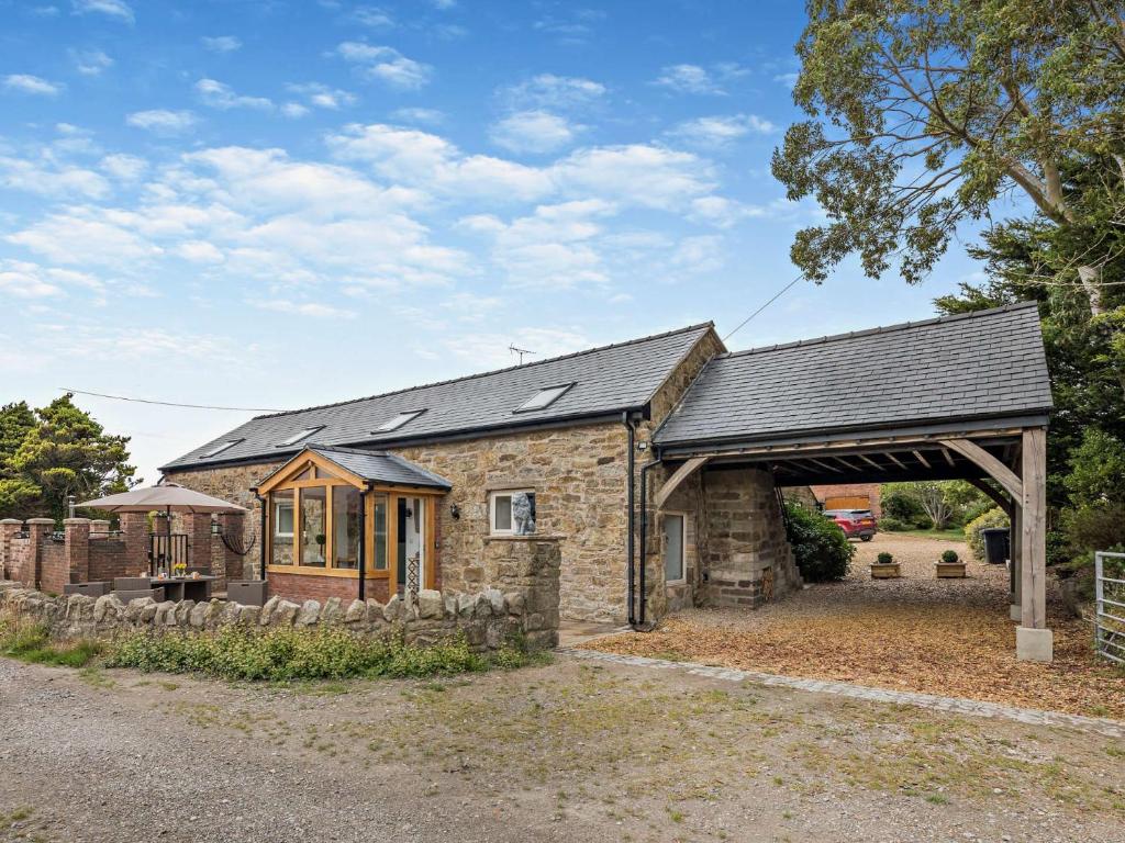 a stone house with a black roof at 4 Bed in Mold 92663 in Treuddyn
