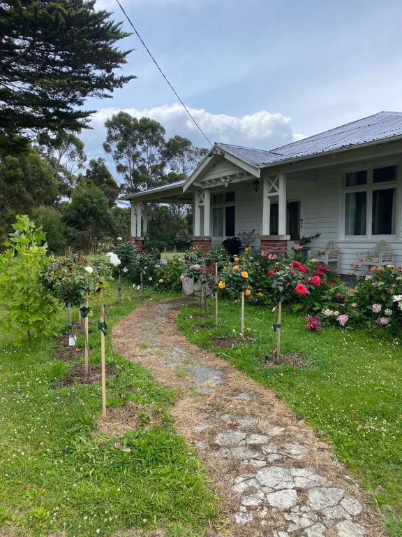a house with a garden of flowers in the yard at River Front Estate in Huonville