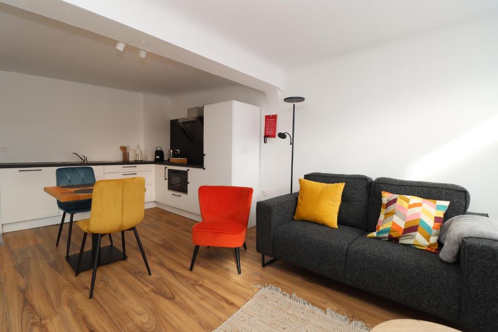 a living room with a couch and a table and chairs at Louisappart - Eupen Zentrum in Eupen