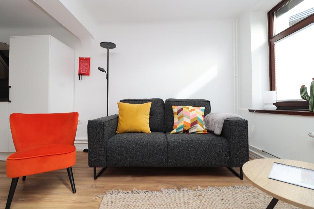 a living room with a couch and a chair at Louisappart - Eupen Zentrum in Eupen